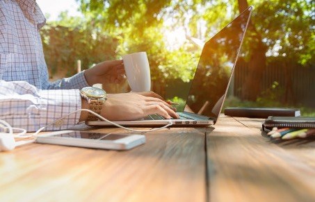 personne travaillant sur son ordinateur dans un parc